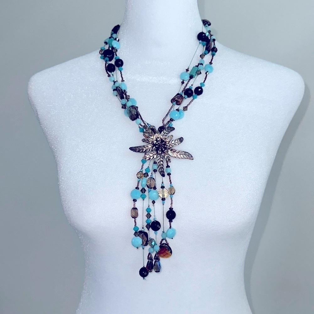 Necklace: Multi-stranded beaded necklace with Silver flower center medallion.